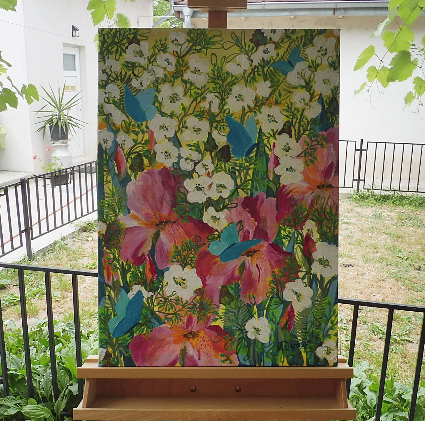 Original painting of iris flowers in the garden, displayed on an easel