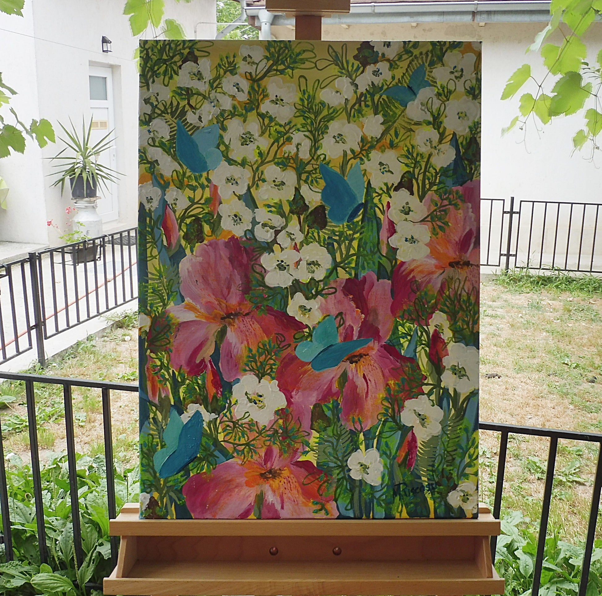 Original painting of iris flowers in the garden, displayed on an easel