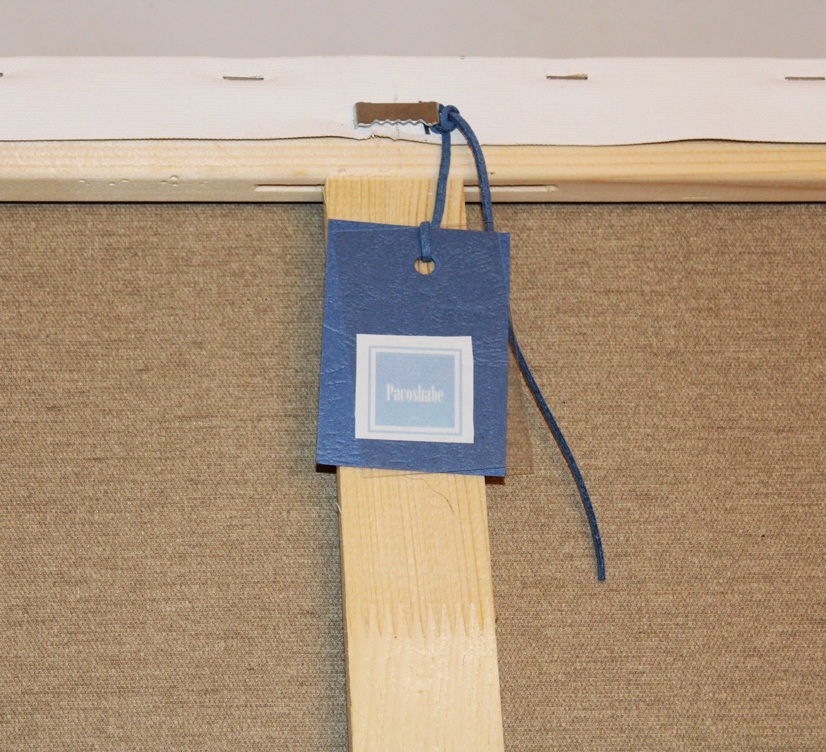 Close-up details of the back of the Blue Butterflies painting with the label reading "Pacoshabe", ready to hang