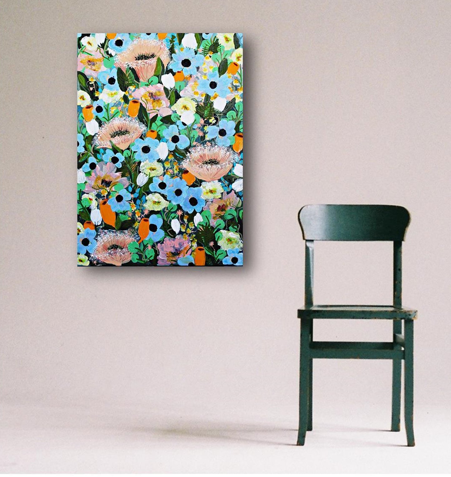 Colorful floral painting with magical summer blooms on a wall next to a green chair