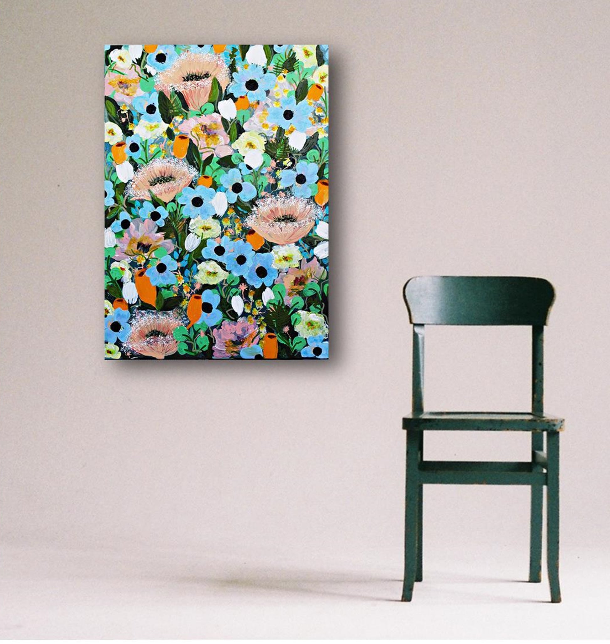 Colorful floral painting with magical summer blooms on a wall next to a green chair