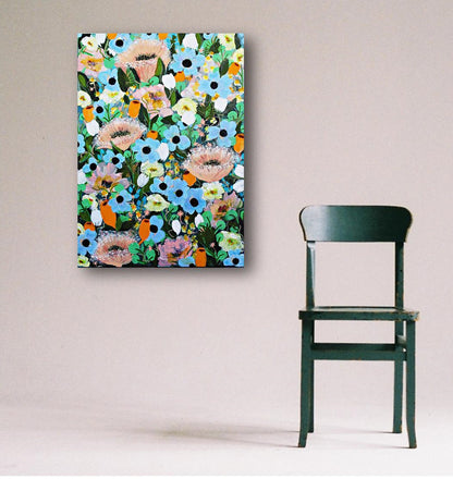 Colorful floral painting with magical summer blooms on a wall next to a green chair